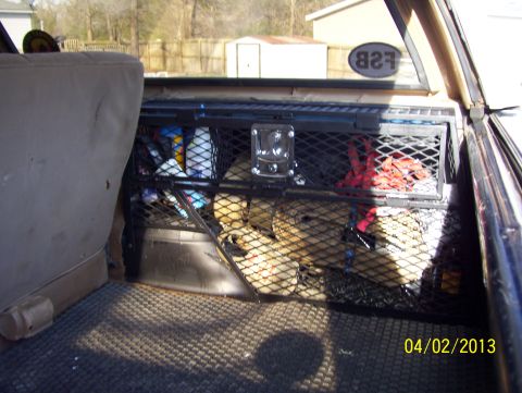 1990 Ford Bronco - Behind-the-seat cargo net and metal storage shelf inside a pickup cab, FSB sticker visible outside; dated 04 02 2013.