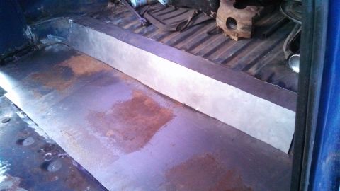 1979 Ford Bronco - The interior of a vehicle shows a metal floor with some rust and a newly installed metal divider. The Supermotors.net logo is visible in th…