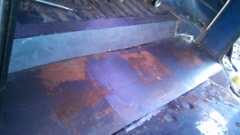 1979 Ford Bronco - The interior of this vehicle shows significant rust on the floor and bench seat, indicating a need for restoration.