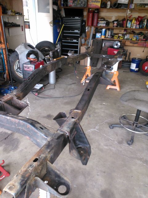 1968 Ford Bronco - A vehicle frame is supported by jack stands in a garage, suggesting a restoration or modification project.