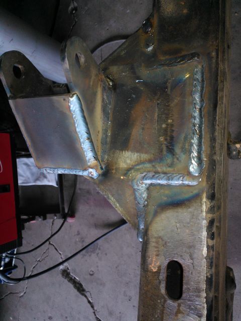1968 Ford Bronco - Close-up of a heavily modified and welded metal frame component, likely part of a vehicle suspension or chassis.