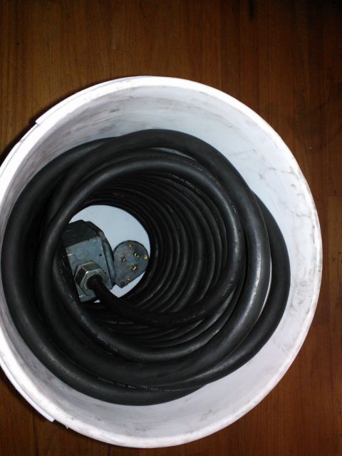 1968 Ford Bronco - Coiled heavy gauge electrical cord with a metal plug, stored in a white bucket.