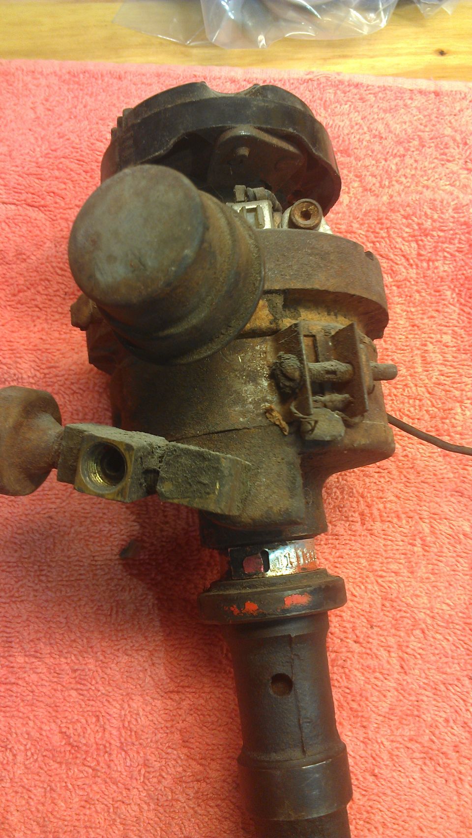 rusted automotive distributor with black cap and metal fittings