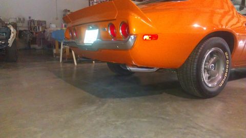 1976 Pontiac Trans Am - Rear view of an orange muscle car, likely from the early 1970s, quad taillights and a prominent spoiler.