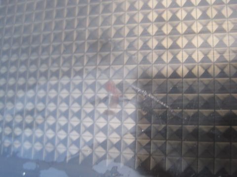 1993 Ford Bronco - A close-up of a textured plastic panel with a diamond pattern is visible, with some scratches and a red mark on its surface.