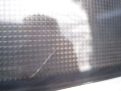 1993 Ford Bronco - A close-up view of a textured surface, possibly a vehicle part, showing a scratch and a watermark.