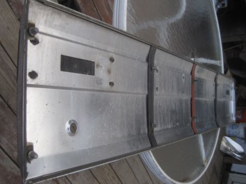 1993 Ford Bronco - This metal panel features a keyhole and several rectangular cutouts, likely a component from a vehicle.