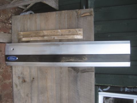 1993 Ford Bronco - A Ford tailgate trim piece with the blue oval logo is mounted on a wooden surface.