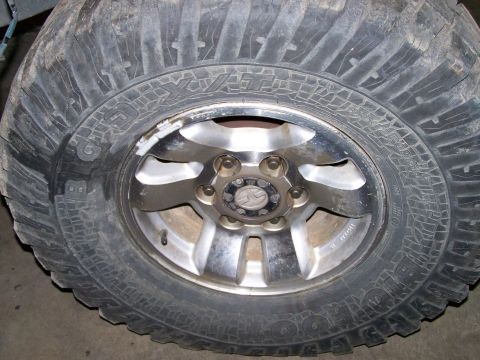 1988 Suzuki Samurai - Close-up of an off-road tire and wheel assembly, showing tread detail and alloy rim.