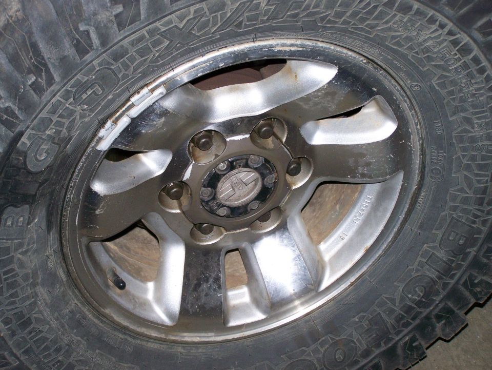 Close-up of a tire and wheel with balance weights on the rim