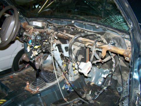 1988 Suzuki Samurai - The interior of a vehicle shows a disassembled dashboard with extensive wiring and a cracked windshield.
