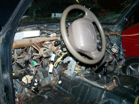 1988 Suzuki Samurai - The interior of a vehicle is shown with the dashboard removed, revealing extensive wiring and components.