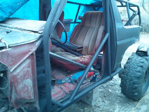 1986 Ford Bronco - This modified Ford Bronco shows extensive roll cage modifications and worn interior seating.