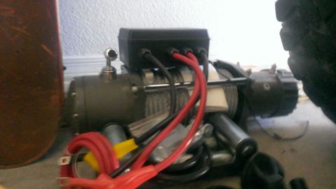 1994 Ford Bronco - Close-up of a winch and its wiring, with a tire visible in the background.