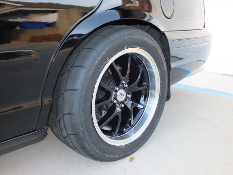 2003 Ford Crown Victoria - Close-up of the rear wheel and tire on a black 2003 Ford Crown Victoria.