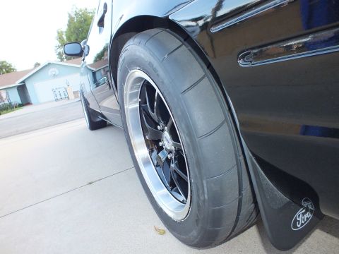 2003 Ford Crown Victoria - Close-up of a car's rear tire and fender, showing a Ford mud flap.