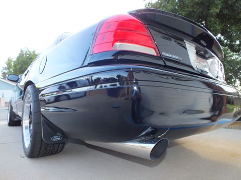 2003 Ford Crown Victoria - The rear of a black Ford Crown Victoria, showing its taillights, spoiler, and exhaust.