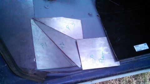 1979 Ford Bronco - Cut metal pieces are prepared for installation on the vehicle's floor panel.
