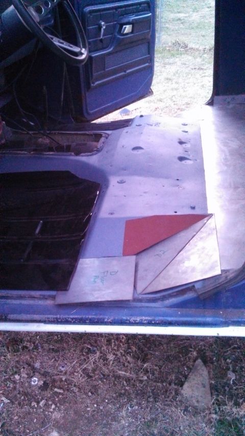 1979 Ford Bronco - Close-up of the interior floor and door panel of a vehicle, showing custom metalwork and a steering wheel.