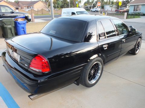 2003 Ford Crown Victoria - Black 2003 Ford Crown Victoria with aftermarket wheels and tires parked on a driveway.
