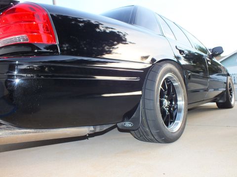 2003 Ford Crown Victoria - The rear of a black 2003 Ford Crown Victoria is shown with custom wheels and tires.