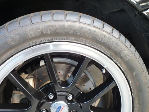 2003 Ford Crown Victoria - A close-up view of a vehicle's tire and wheel assembly, a Ford Racing center cap.