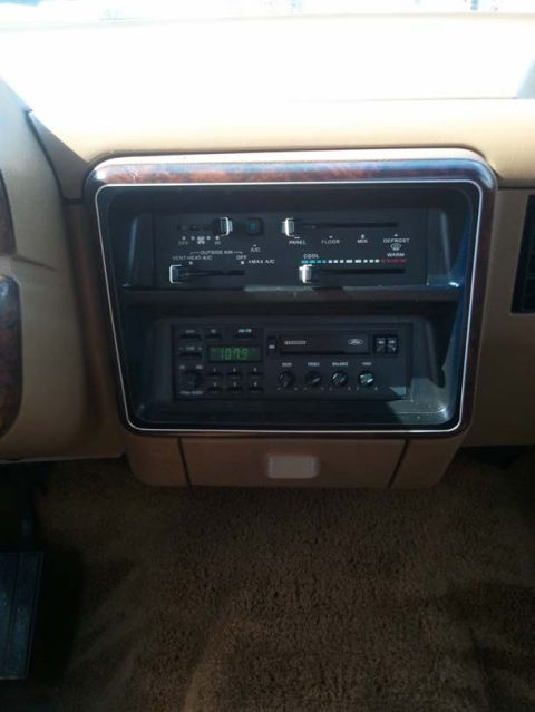 1988 Ford Bronco - The dashboard of a 1988 Ford Bronco features wood grain trim and a Ford radio unit.
