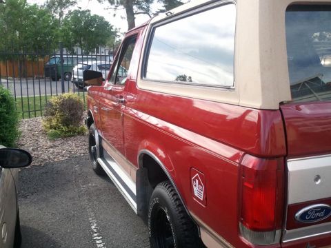 1988 Ford Bronco - This red Ford Bronco has a tan removable top and a two-tone paint scheme with a tan stripe.