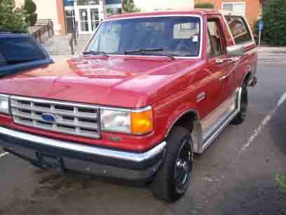 1988 Ford Bronco - This red 1988 Ford Bronco is seen from a 3q-front angle, highlighting its grille.