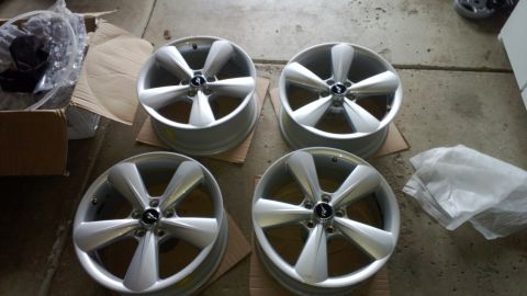 2008 Mercury Grand Marquis - A set of four alloy wheels, likely for a performance car, are shown resting on cardboard in a garage or workshop.