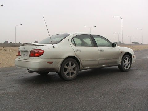 2004 Nissan Maxima - A white Nissan Maxima is seen from the rear on a cloudy day.
