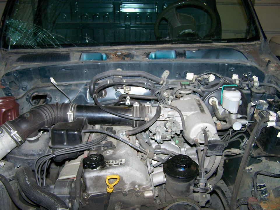 Engine bay with cracked windshield and visible engine components