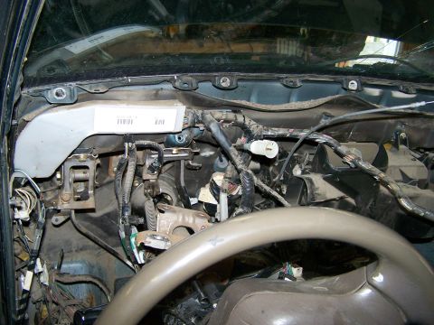 1988 Suzuki Samurai - Close-up view of the complex wiring and components within a vehicle's dashboard, with a steering wheel in the foreground.