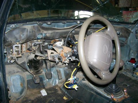 1988 Suzuki Samurai - The interior of a vehicle is shown with the dashboard removed, revealing the steering column and wiring.