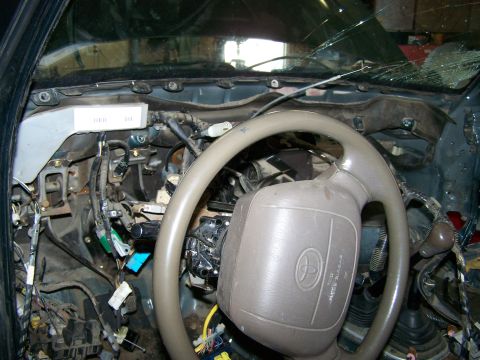 1988 Suzuki Samurai - The interior of a vehicle shows a disassembled dashboard with exposed wiring and a steering wheel with a Toyota logo.