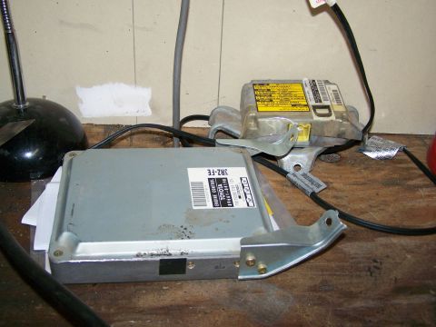1988 Suzuki Samurai - Engine control unit and airbag module are shown on a workbench.