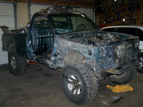 1988 Suzuki Samurai - This heavily modified truck shows significant damage to its front end and body, with its engine compartment exposed.