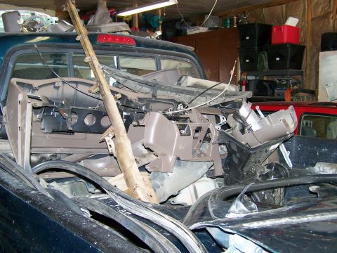 1988 Suzuki Samurai - Vehicle parts, including a dashboard, are piled in the bed of a pickup truck.
