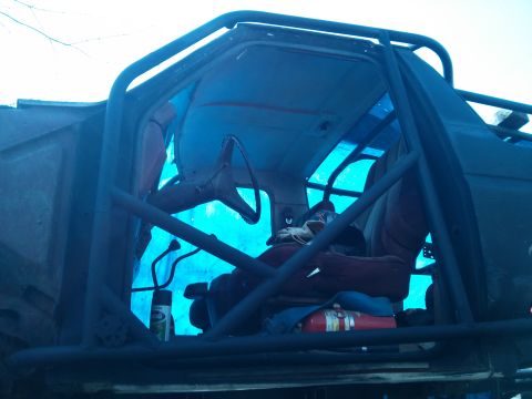 1986 Ford Bronco - Modified 1986 Ford Bronco interior a roll cage and a fire extinguisher visible.