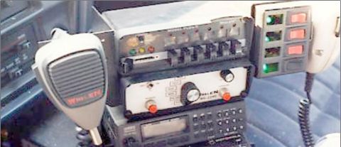 1991 Ford LTD Crown Victoria - Close-up of police radio equipment, including a microphone and various control switches.