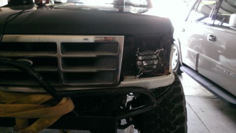 1994 Ford Bronco - Front view of a Ford Bronco, with a white SUV visible to the right.