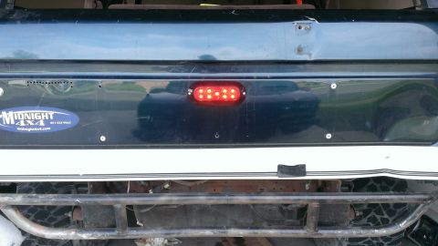 1994 Ford Bronco - The rear of an SUV shows an aftermarket LED light bar and a sticker for 'Midnight 4x4'.