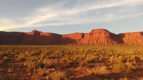 1994 Ford Bronco - A wide view of a desert landscape with mesas bathed in the warm light of sunset.