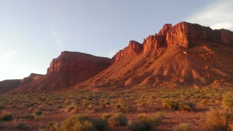 1994 Ford Bronco - A vast desert landscape is illuminated by the warm glow of the setting sun, highlighting the mountain range.