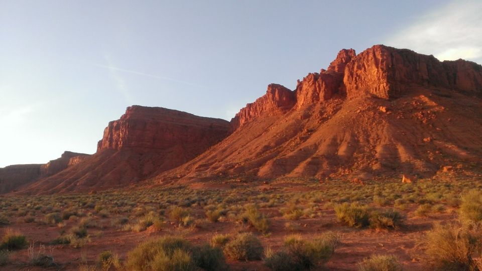 Red rock mountains under a clear sky with desert scrub in the foreground. A "SUPERMOTORS" watermark is visible