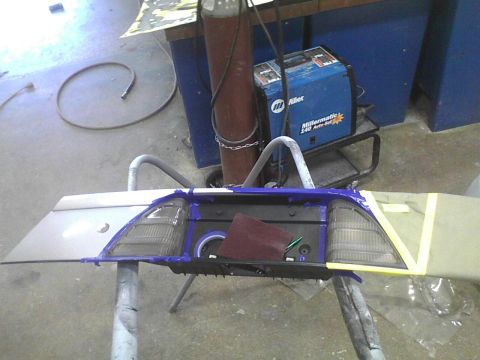 2003 Ford Crown Victoria - A disassembled car tail light assembly is being worked on in a workshop, with welding equipment in the background.