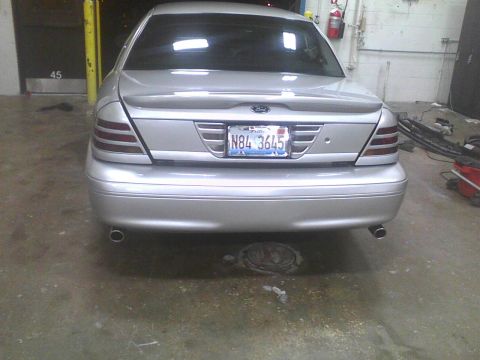 2003 Ford Crown Victoria - Rear view of a silver 2003 Ford Crown Victoria, showing its distinctive taillights and license plate.