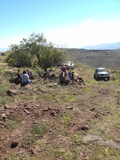 1981 Ford F-150 - A group of people take a break during an off-road trip, with two vehicles visible in the background.