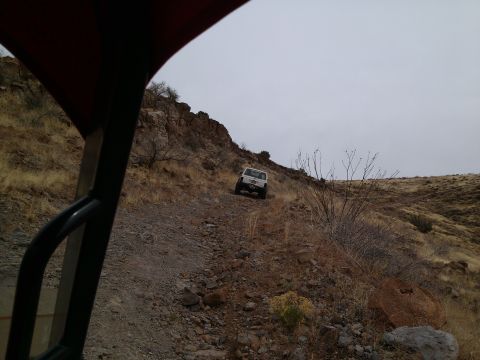 1981 Ford F-150 - A white SUV navigates a challenging, rocky incline on an off-road trail.