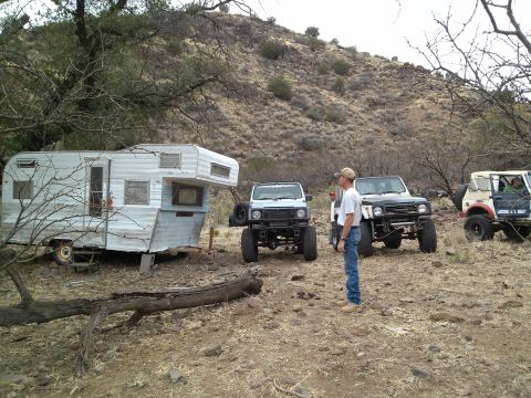 1981 Ford F-150 - Several off-road vehicles and a trailer are parked in a dry, hilly area.